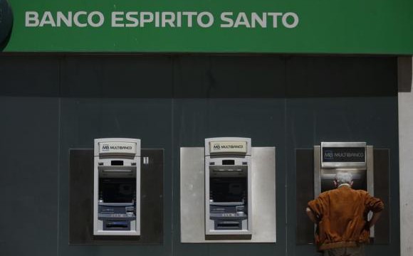 A man uses an automated teller machine of Portuguese bank Banco Espirito Santo in downtown Lisbon