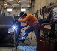 A worker welds a metal furnace in a factory in Gravellona Lomellina