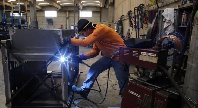 A worker welds a metal furnace in a factory in Gravellona Lomellina